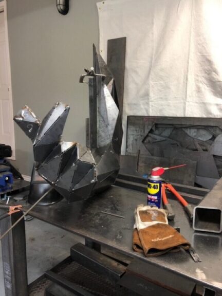 Welded steel hand and forearm panel in progress on a bench