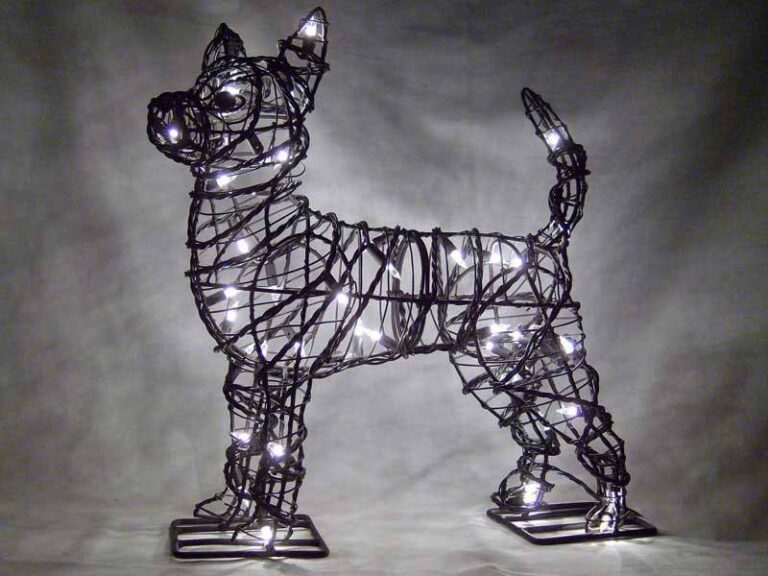 Wire chihuahua topiary frame lit with clear miniature bulbs, standing on flat metal base plates
