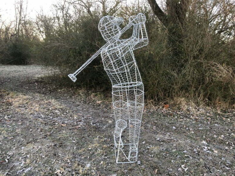 Bare wire-frame golfer topiary sculpture outdoors, mid-swing, foliage not yet added