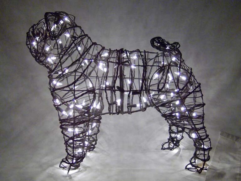 Wire-frame pug topiary lit with small white lights against a dark background