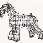 Wire-frame schnauzer topiary in black wire, showing pointed ears, muzzle, and legs, on a plain background.