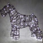 Wire-frame schnauzer topiary lit with small white lights against a dark background