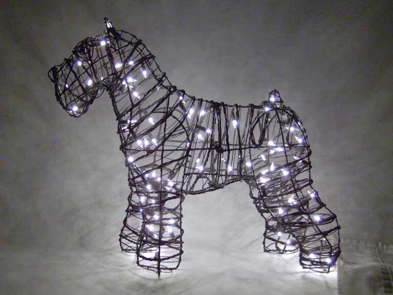 Wire-frame schnauzer topiary lit with small white lights against a dark background
