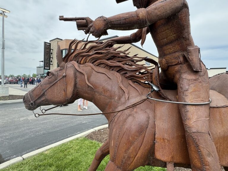 Welded-steel horse's head and rider's torso, mane detail visible