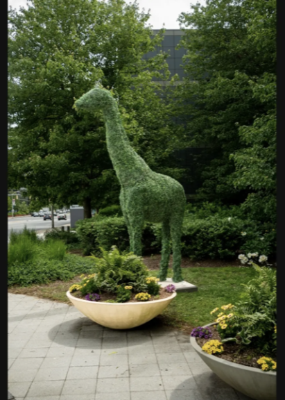 Bare wire giraffe topiary frame standing on grass among trees