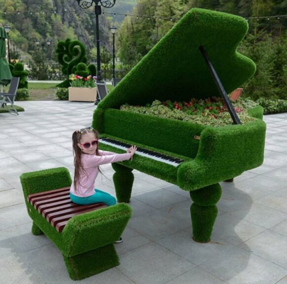 Grand piano sculpture with matching bench in green artificial turf