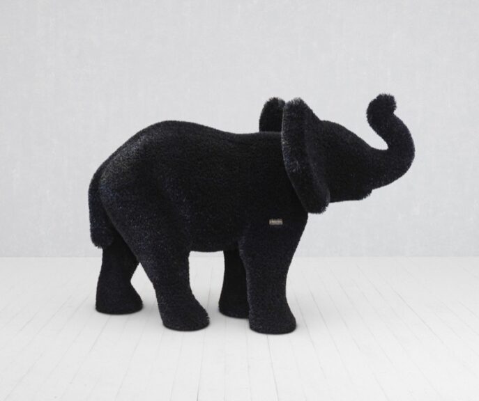 Black elephant topiary sculpture with a plush fuzzy finish, trunk raised