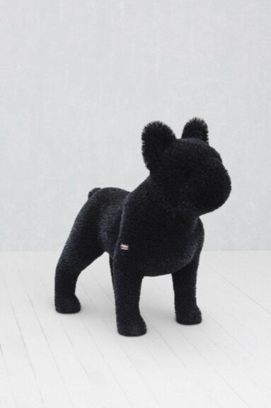 Black dog-shaped topiary sculpture, floor-standing, displayed indoors.