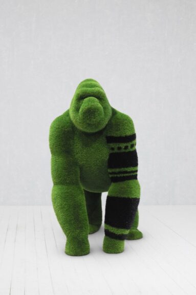 A kneeling gorilla sculpture covered in green turf-like material.