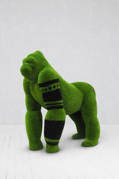 Gorilla-shaped topiary sculpture in green artificial turf with black detailing.