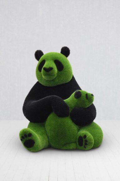 Turf-wrapped panda sculpture in green and black tones, shown seated on a white floor