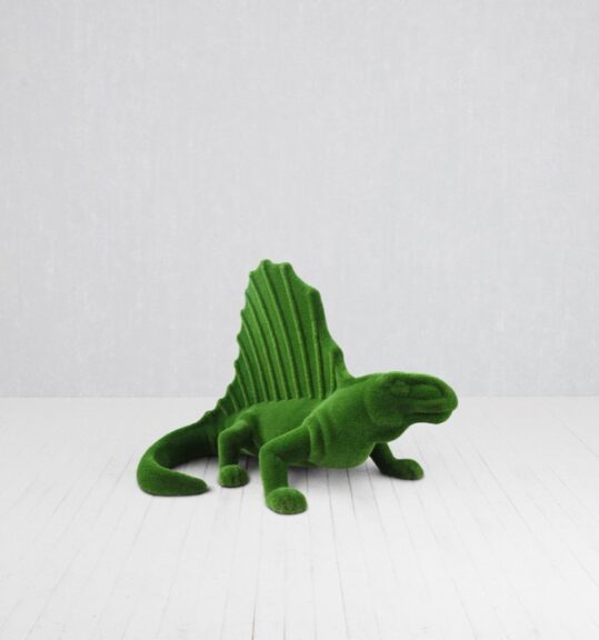 Green dinosaur-shaped sculpture covered in artificial turf