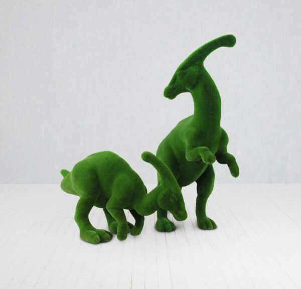 Green turf-covered dinosaur sculpture shown on a white floor