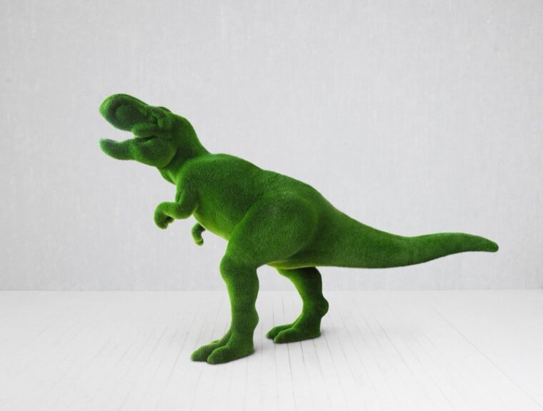 Green artificial-grass dinosaur statue displayed indoors