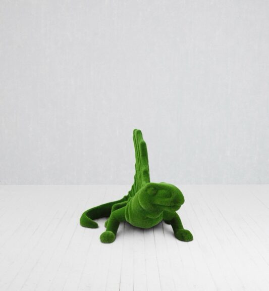 Green turf-covered chair sculpted into a minimalist iguana silhouette
