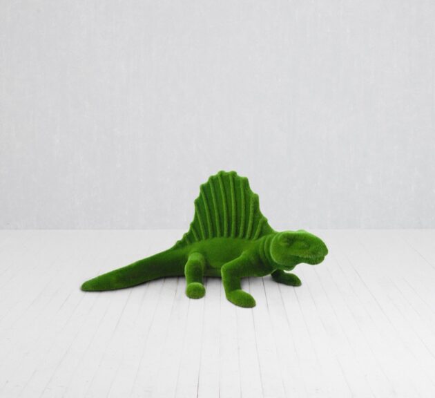 Green moss-covered dinosaur statue topiary shown on a white floor