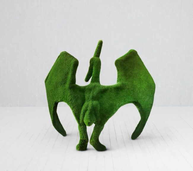 Green turf-covered pterodactyl sculpture with outstretched wings
