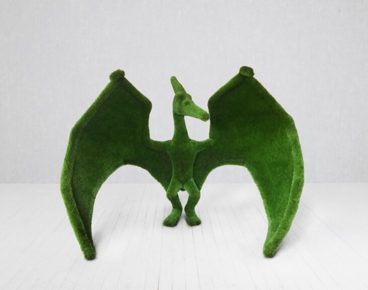 Green topiary dinosaur with wing detailing, covered in turf