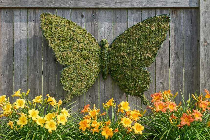 Concept rendering of a flat mossed butterfly with open wings fixed to a wooden garden fence