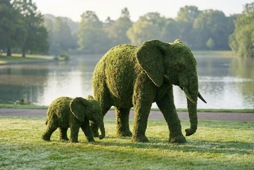 Concept rendering of a large moss elephant with a calf walking beside her in a park