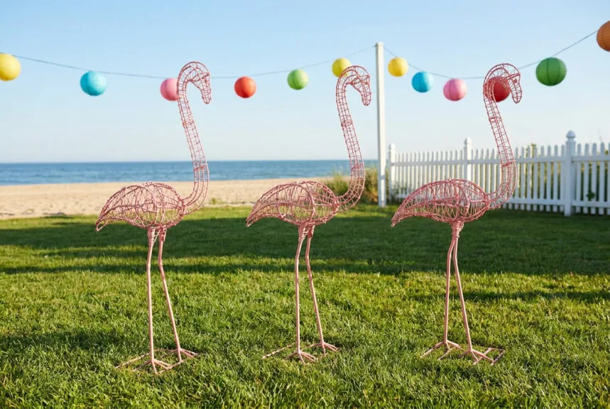 Concept rendering of three bare wire flamingo frames in pink powder coat on a beach lawn