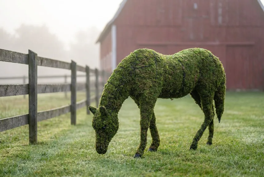 Concept rendering of a life-size moss grazing horse topiary in a paddock beside a barn