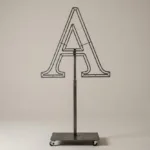 Monogram letter A topiary frame in Cinzel style, bare galvanized steel on an adjustable stand