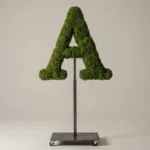 Monogram letter A topiary in Cinzel style, packed with green moss, on an adjustable stand