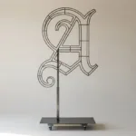 Monogram letter A topiary frame in Custom style, bare galvanized steel on an adjustable stand