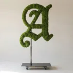 Monogram letter A topiary in Custom style, packed with green moss, on an adjustable stand