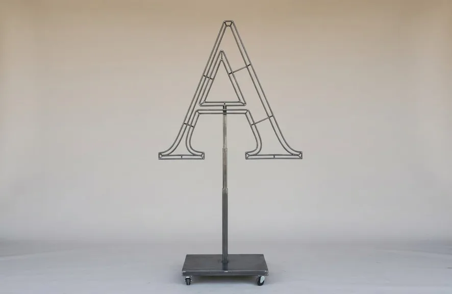 Monogram letter A topiary frame in Roman style, bare galvanized steel on an adjustable stand