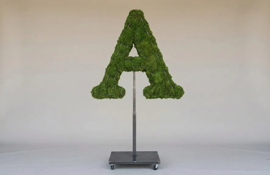 Monogram letter A topiary in Roman style, packed with green moss, on an adjustable stand