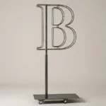 Monogram letter B topiary frame in Cinzel style, bare galvanized steel on an adjustable stand