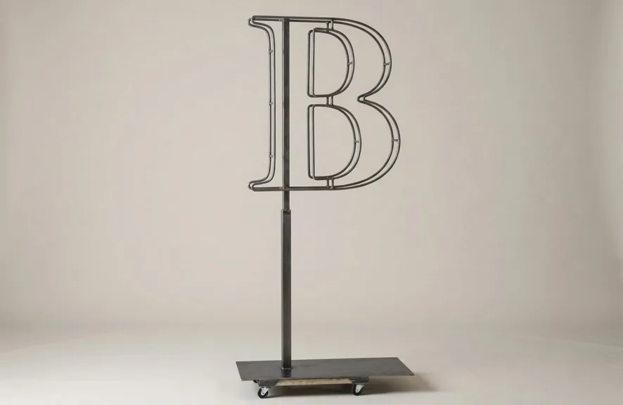Monogram letter B topiary frame in Cinzel style, bare galvanized steel on an adjustable stand