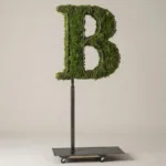 Monogram letter B topiary in Cinzel style, packed with green moss, on an adjustable stand