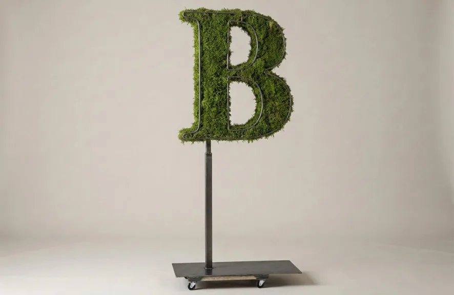 Monogram letter B topiary in Cinzel style, packed with green moss, on an adjustable stand