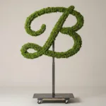 Monogram letter B topiary in Flowing script style, packed with green moss, on an adjustable stand