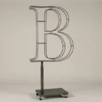 Monogram letter B topiary frame in Roman style, bare galvanized steel on an adjustable stand