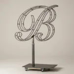 Monogram letter B topiary frame in Script style, bare galvanized steel on an adjustable stand