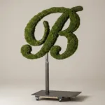 Monogram letter B topiary in Script style, packed with green moss, on an adjustable stand