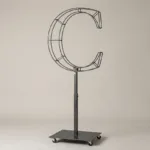 Monogram letter C topiary frame in Cinzel style, bare galvanized steel on an adjustable stand