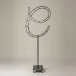 Monogram letter C topiary frame in Flowing script style, bare galvanized steel on an adjustable stand