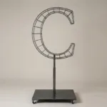 Monogram letter C topiary frame in Roman style, bare galvanized steel on an adjustable stand