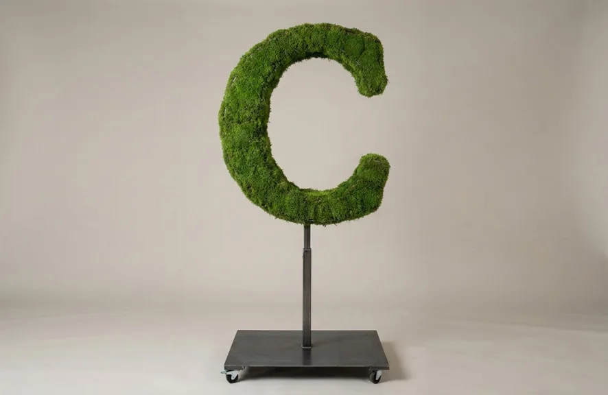 Monogram letter C topiary in Roman style, packed with green moss, on an adjustable stand