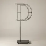Monogram letter D topiary frame in Cinzel style, bare galvanized steel on an adjustable stand