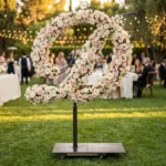 Monogram letter D topiary covered in flowers as a photo backdrop at a garden wedding