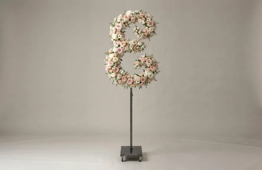 Monogram letter E topiary in script style, covered in pink and white roses