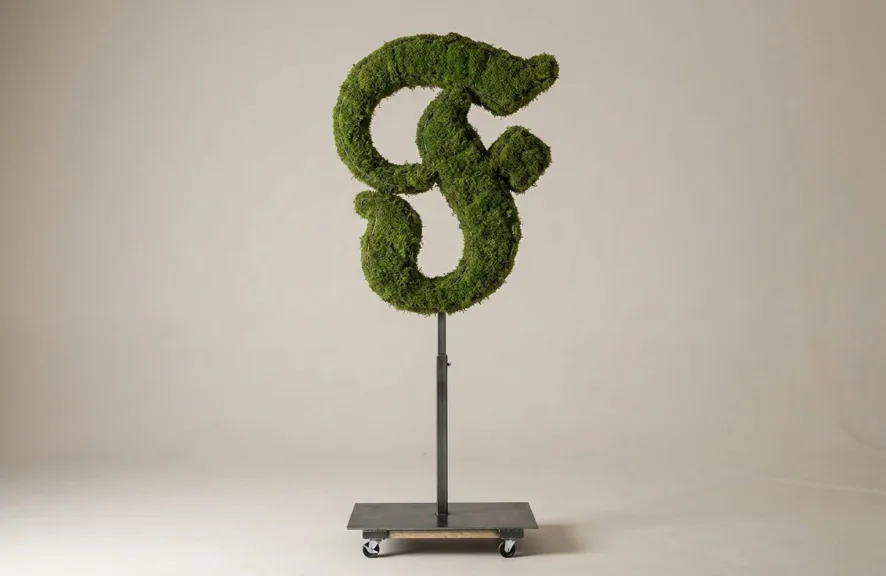 Monogram letter F topiary in Custom style, packed with green moss, on an adjustable stand