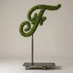 Monogram letter F topiary in Flowing script style, packed with green moss, on an adjustable stand
