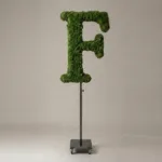 Monogram letter F topiary in Roman style, packed with green moss, on an adjustable stand